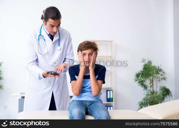 The young male doctor examining boy in the clinic. Young male doctor examining boy in the clinic