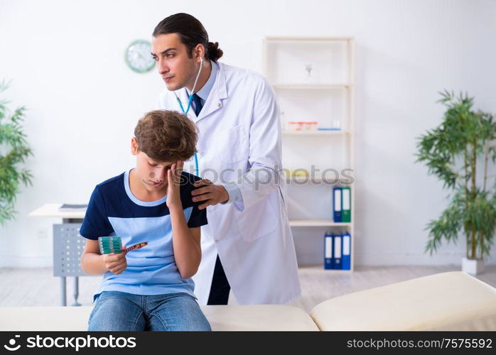 The young male doctor examining boy in the clinic. Young male doctor examining boy in the clinic