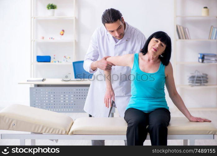 The young male doctor examining old female patient. Young male doctor examining old female patient