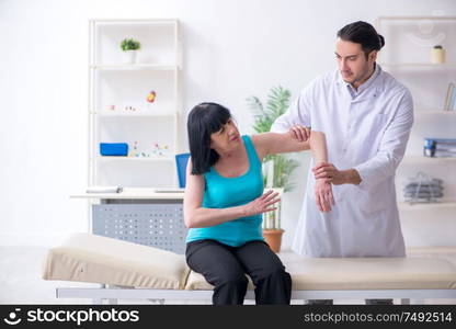 The young male doctor examining old female patient. Young male doctor examining old female patient