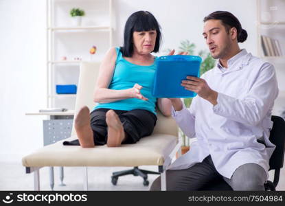 The young male doctor examining old female patient. Young male doctor examining old female patient