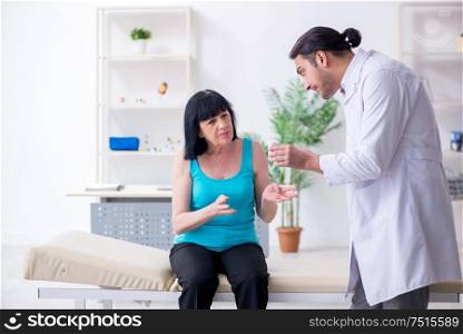 The young male doctor examining old female patient. Young male doctor examining old female patient
