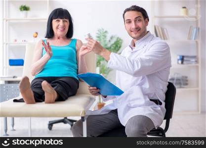 The young male doctor examining old female patient. Young male doctor examining old female patient