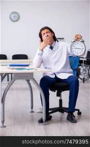 The young male doctor in time management concept . Young male doctor in time management concept