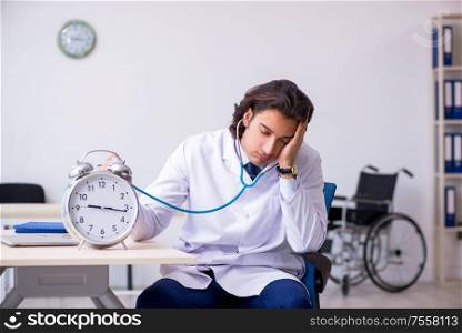 The young male doctor in time management concept. Young male doctor in time management concept