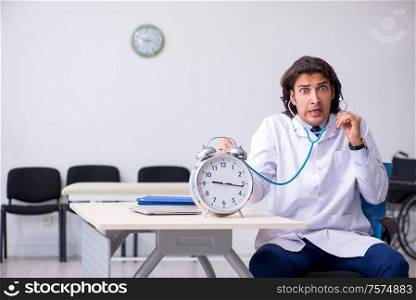 The young male doctor in time management concept. Young male doctor in time management concept