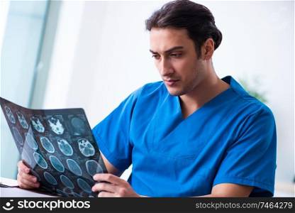 The young male doctor looking at x-ray images. Young male doctor looking at x-ray images