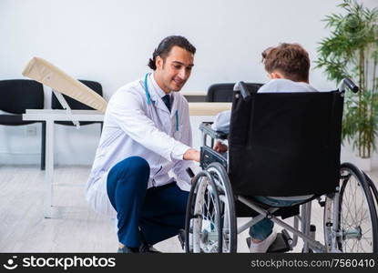 The young male doctor pediatrist and boy in wheel-chair. Young male doctor pediatrist and boy in wheel-chair