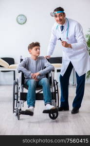 The young male doctor pediatrist and boy in wheel-chair. Young male doctor pediatrist and boy in wheel-chair