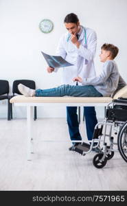 The young male doctor pediatrist and boy in wheel-chair. Young male doctor pediatrist and boy in wheel-chair