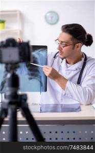 The young male doctor radiologist recording video for his blog . Young male doctor radiologist recording video for his blog