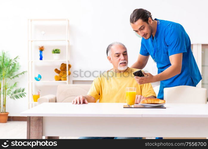 The young male doctor visiting old patient at home. Young male doctor visiting old patient at home