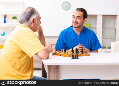 The young male doctor visiting old patient at home. Young male doctor visiting old patient at home