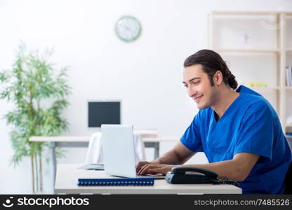 The young male doctor working in the clinic . Young male doctor working in the clinic