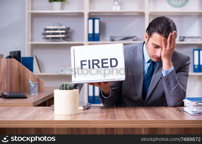 The young male employee being fired from his work . Young male employee being fired from his work