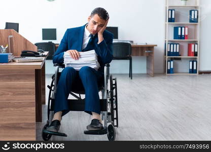 The young male employee in wheel-chair. Young male employee in wheel-chair