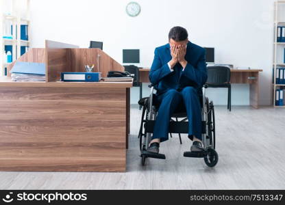 The young male employee in wheel-chair. Young male employee in wheel-chair