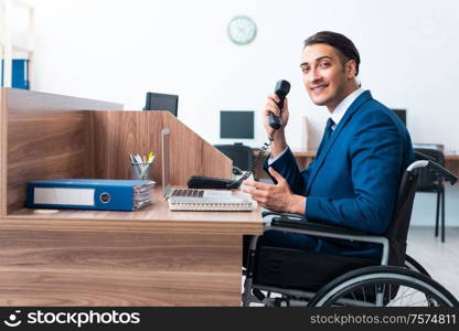 The young male employee in wheel-chair. Young male employee in wheel-chair