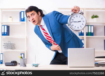 The young male employee suffering in the office. Young male employee suffering in the office