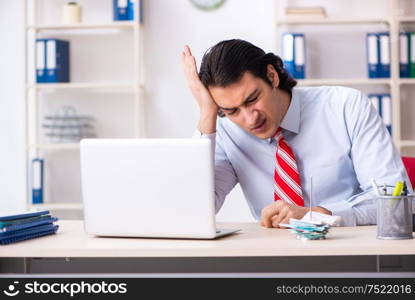 The young male employee suffering in the office. Young male employee suffering in the office