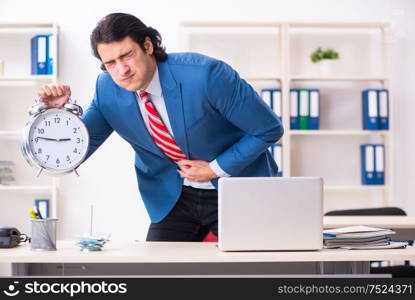 The young male employee suffering in the office. Young male employee suffering in the office