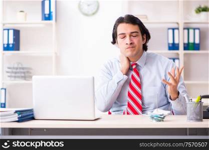 The young male employee suffering in the office. Young male employee suffering in the office