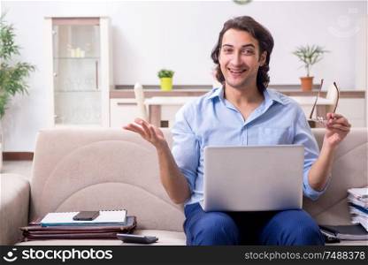 The young male employee working at home . Young male employee working at home