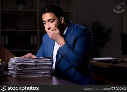 The young male employee working night in the office. Young male employee working night in the office