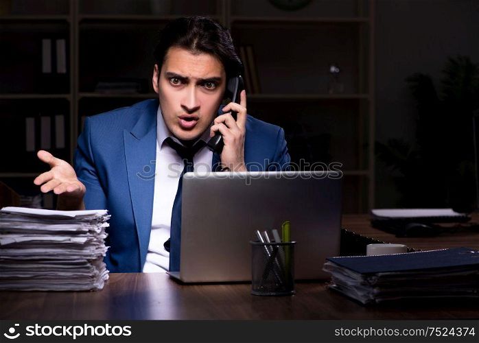 The young male employee working night in the office. Young male employee working night in the office
