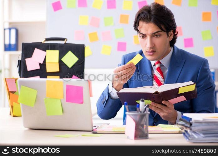 The young male handsome employee in conflicting priorities concept. Young male handsome employee in conflicting priorities concept