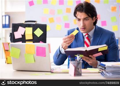 The young male handsome employee in conflicting priorities concept. Young male handsome employee in conflicting priorities concept
