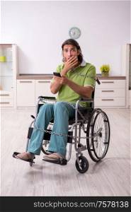 The young male invalid in wheel-chair suffering at home. Young male invalid in wheel-chair suffering at home