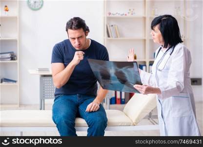 The young male patient visiting aged female doctor . Young male patient visiting aged female doctor 