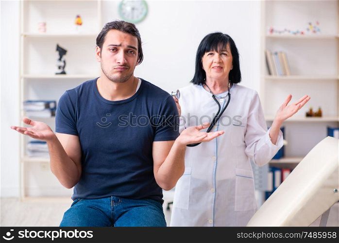 The young male patient visiting aged female doctor . Young male patient visiting aged female doctor