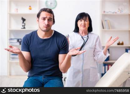 The young male patient visiting aged female doctor . Young male patient visiting aged female doctor
