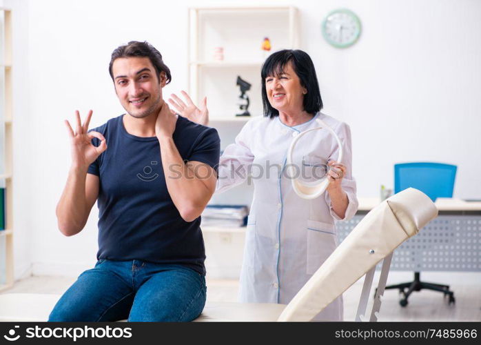 The young male patient visiting aged female doctor. Young male patient visiting aged female doctor