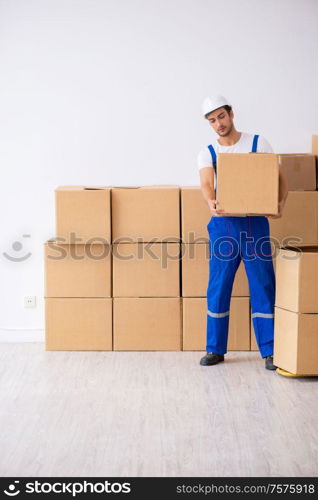 The young male professional mover doing home relocation. Young male professional mover doing home relocation