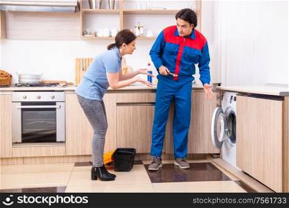 The young male repairman repairing washing machine. Young male repairman repairing washing machine
