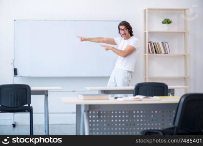 The young male student in front of whiteboard . Young male student in front of whiteboard