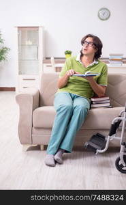 The young male student in wheelchair at home. Young male student in wheelchair at home