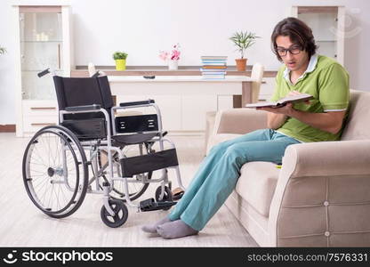 The young male student in wheelchair at home. Young male student in wheelchair at home