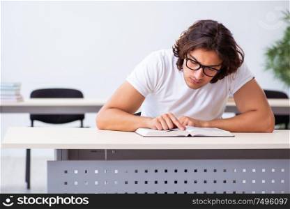 The young male student sitting in the classroom. Young male student sitting in the classroom
