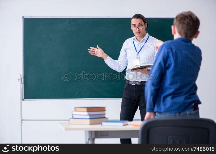 The young male teacher and boy in the classroom . Young male teacher and boy in the classroom