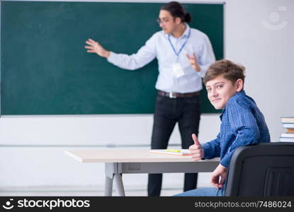 The young male teacher and boy in the classroom. Young male teacher and boy in the classroom