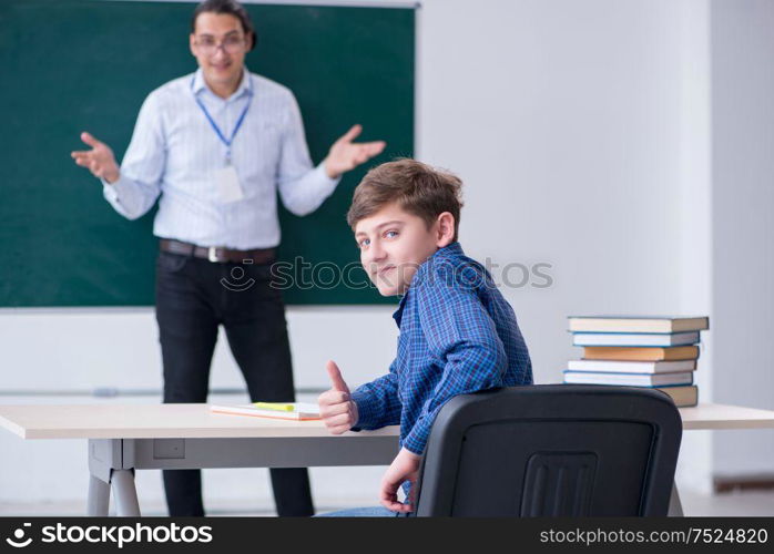 The young male teacher and boy in the classroom. Young male teacher and boy in the classroom