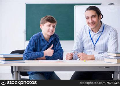 The young male teacher and boy in the classroom. Young male teacher and boy in the classroom