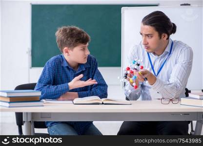 The young male teacher explaining molecular model. Young male teacher explaining molecular model