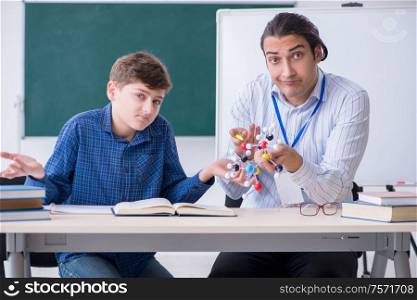 The young male teacher explaining molecular model. Young male teacher explaining molecular model