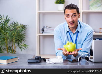 The young male travel agent working in the office. Young male travel agent working in the office