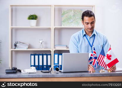 The young male travel agent working in the office. Young male travel agent working in the office